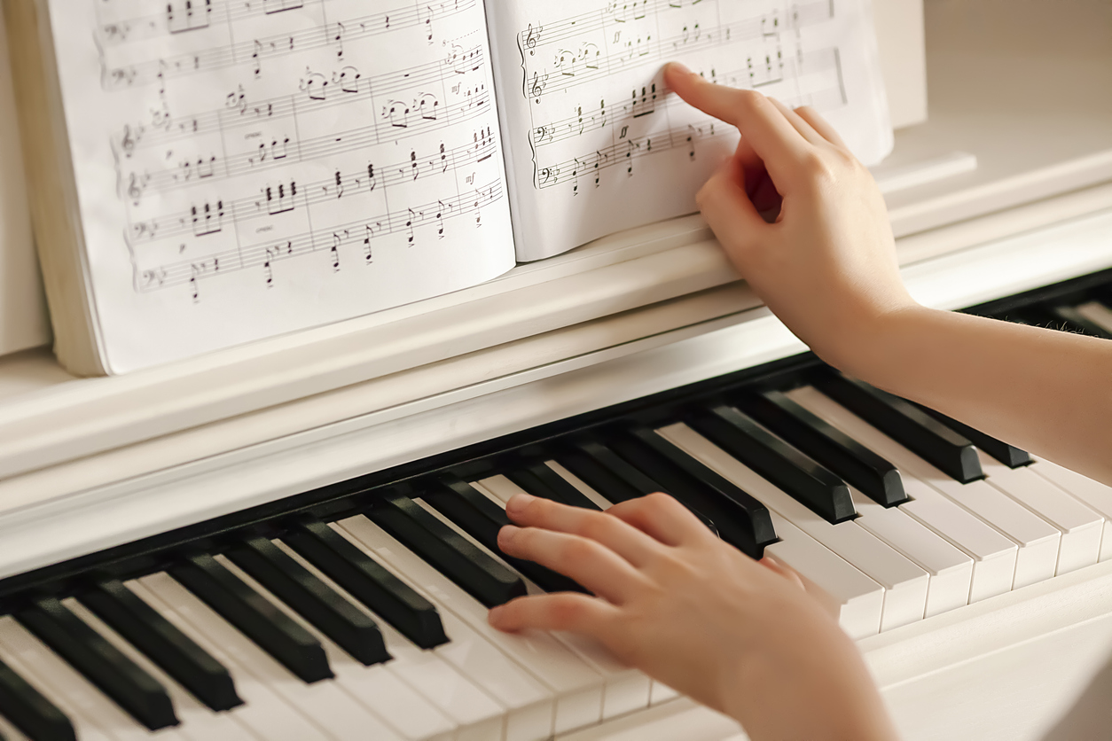 Hands of child learning to play the piano