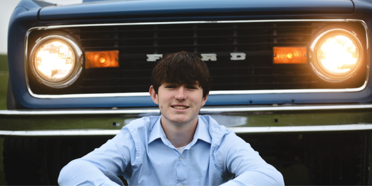 Jacob sitting in front of a vintage Ford pickup truck